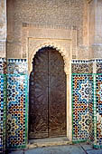 Marrakech - la Madrasa di Ben Youssef, Decorazioni a stucco con iscrizione coranica in rilievo su una base di mattonelle zellij 